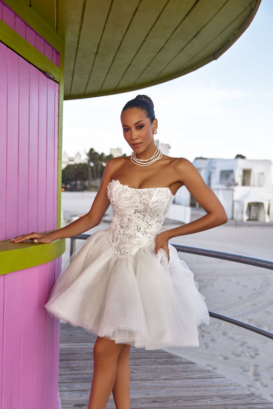 Modern bridal style dresses featuring a strapless lace bodice and playful tulle skirt against a beach backdrop.