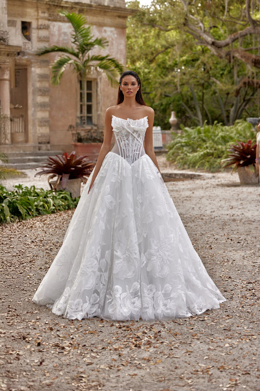 A-line wedding dress featuring a transparent corset and elegant floral details in a beautiful outdoor setting.