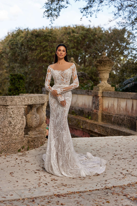 textured wedding dress with lining featuring long sleeves and a fitted silhouette in an outdoor setting