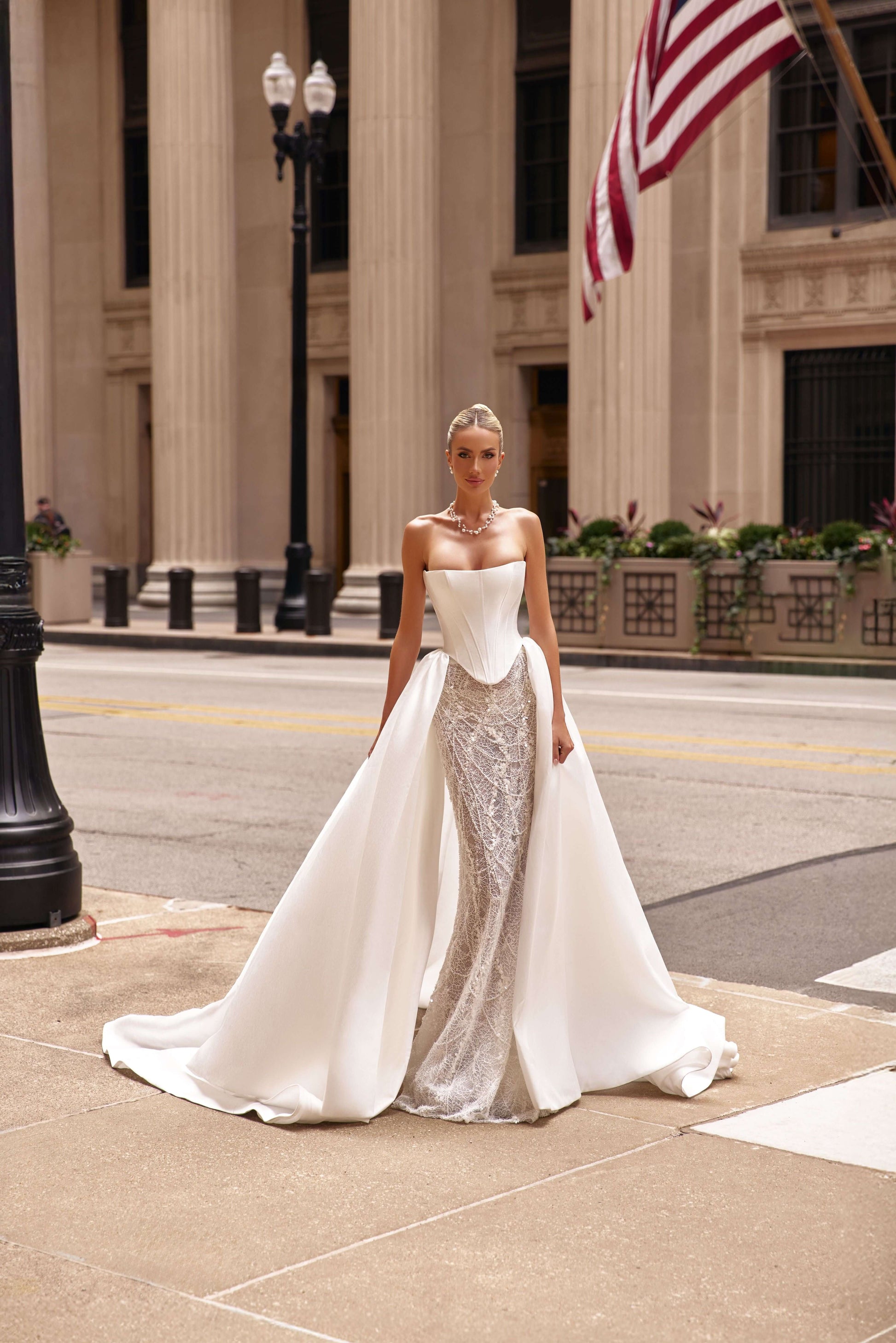 Elegant model wearing a stunning shantung satin corset dress with a flowing train, showcased in an urban setting.