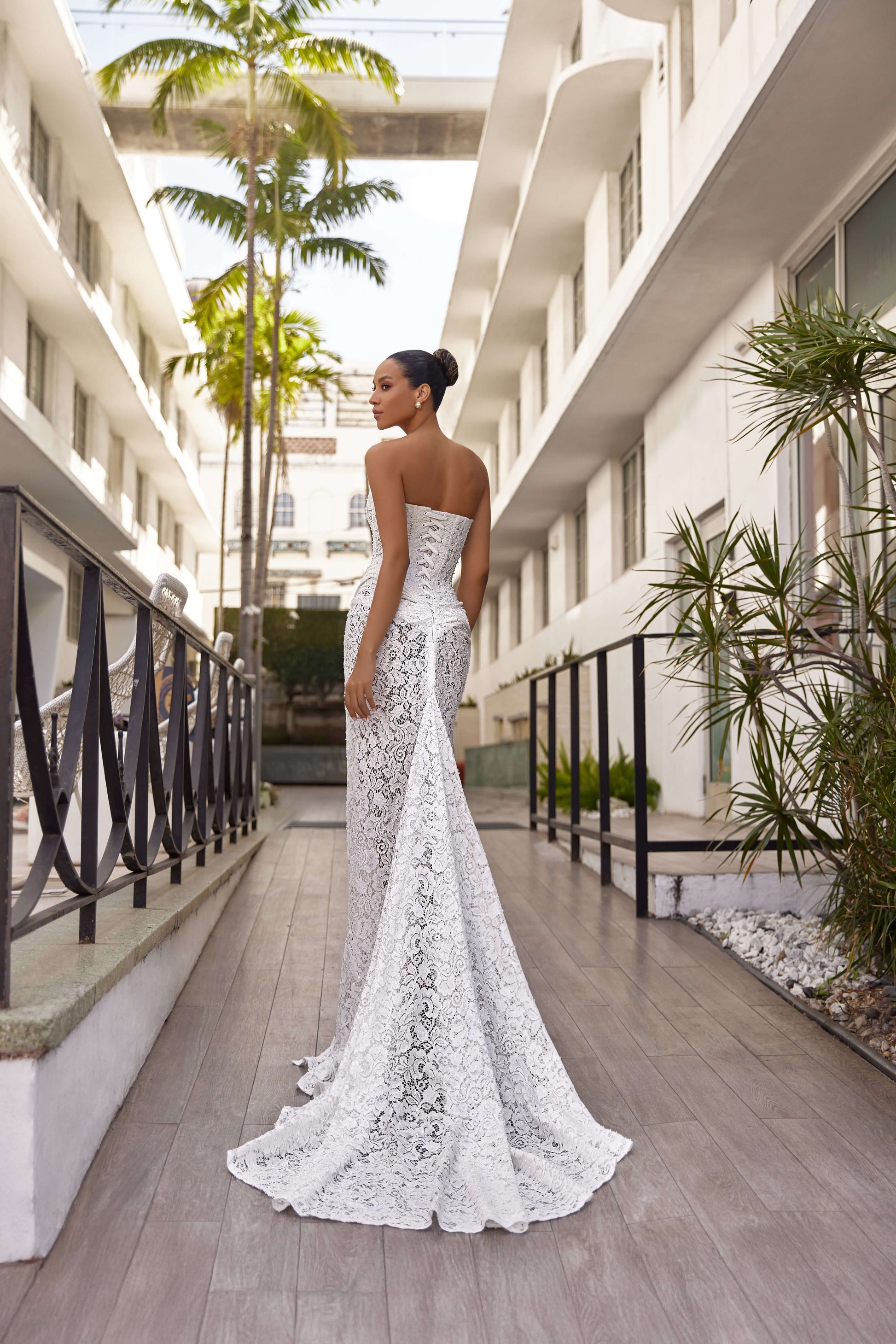 Elegant model showcasing a back view of a modern wedding dress elegance in a stylish outdoor setting.