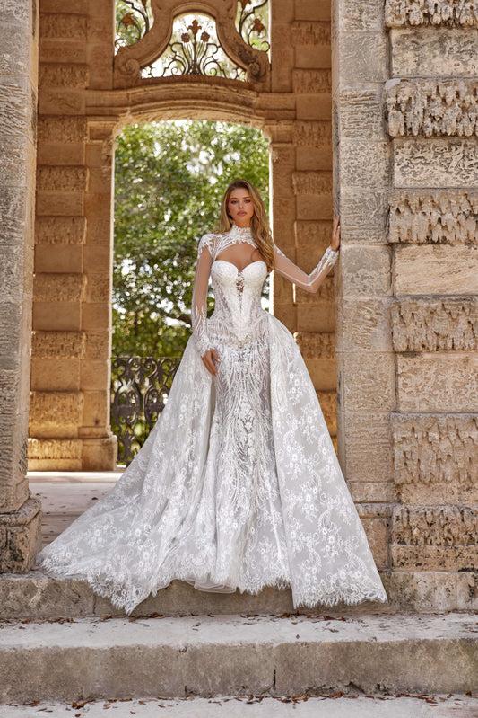 Stunning dress train silhouette featuring a gorgeous model wearing an elegant white gown in a picturesque stone archway.