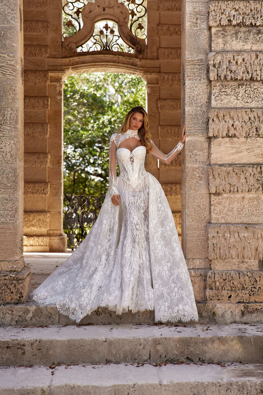 Stunning dress train silhouette featuring a beautiful model in an elegant lace wedding dress standing in a historic setting.