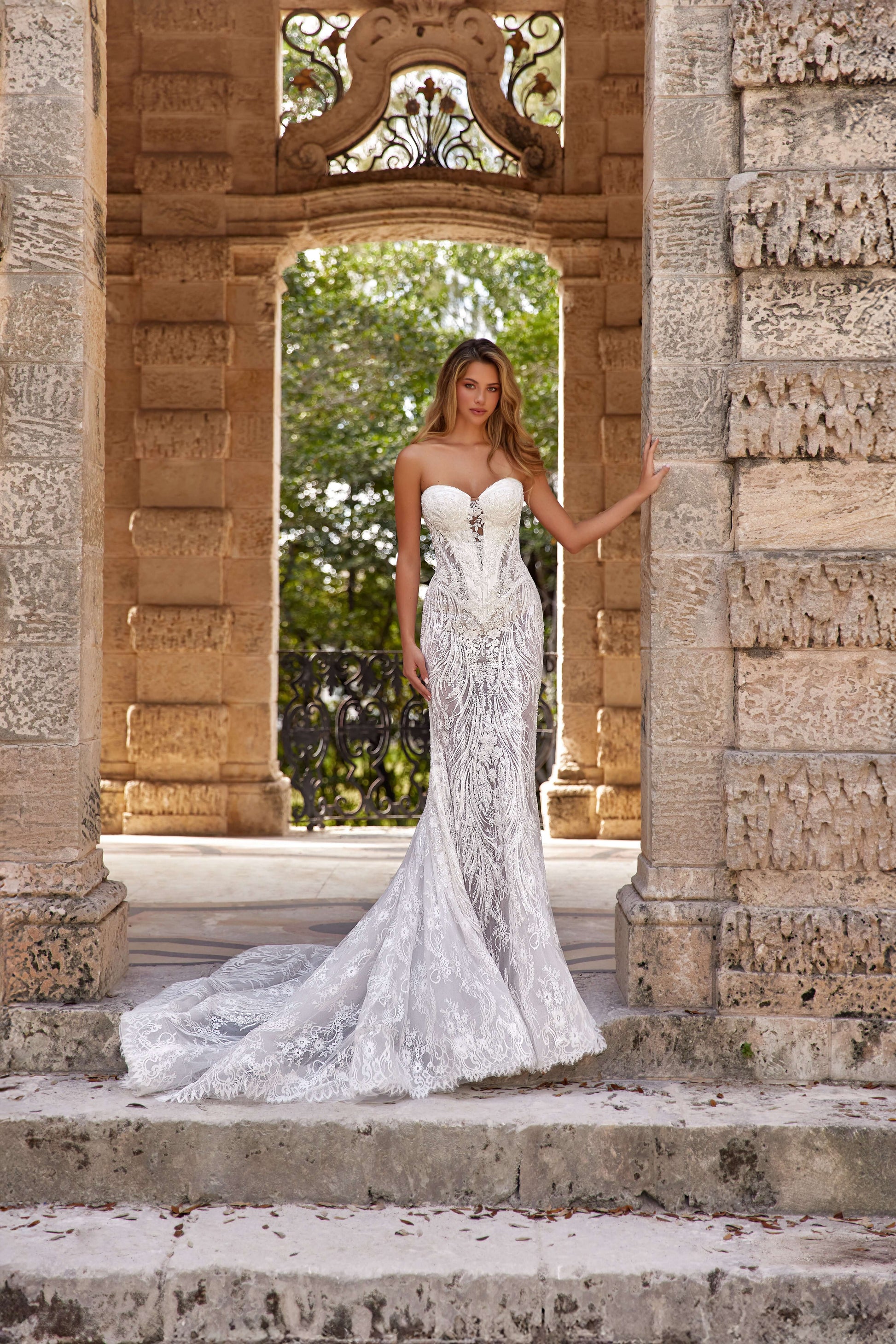 Model wearing a stunning dress train silhouette in a beautiful outdoor stone location.
