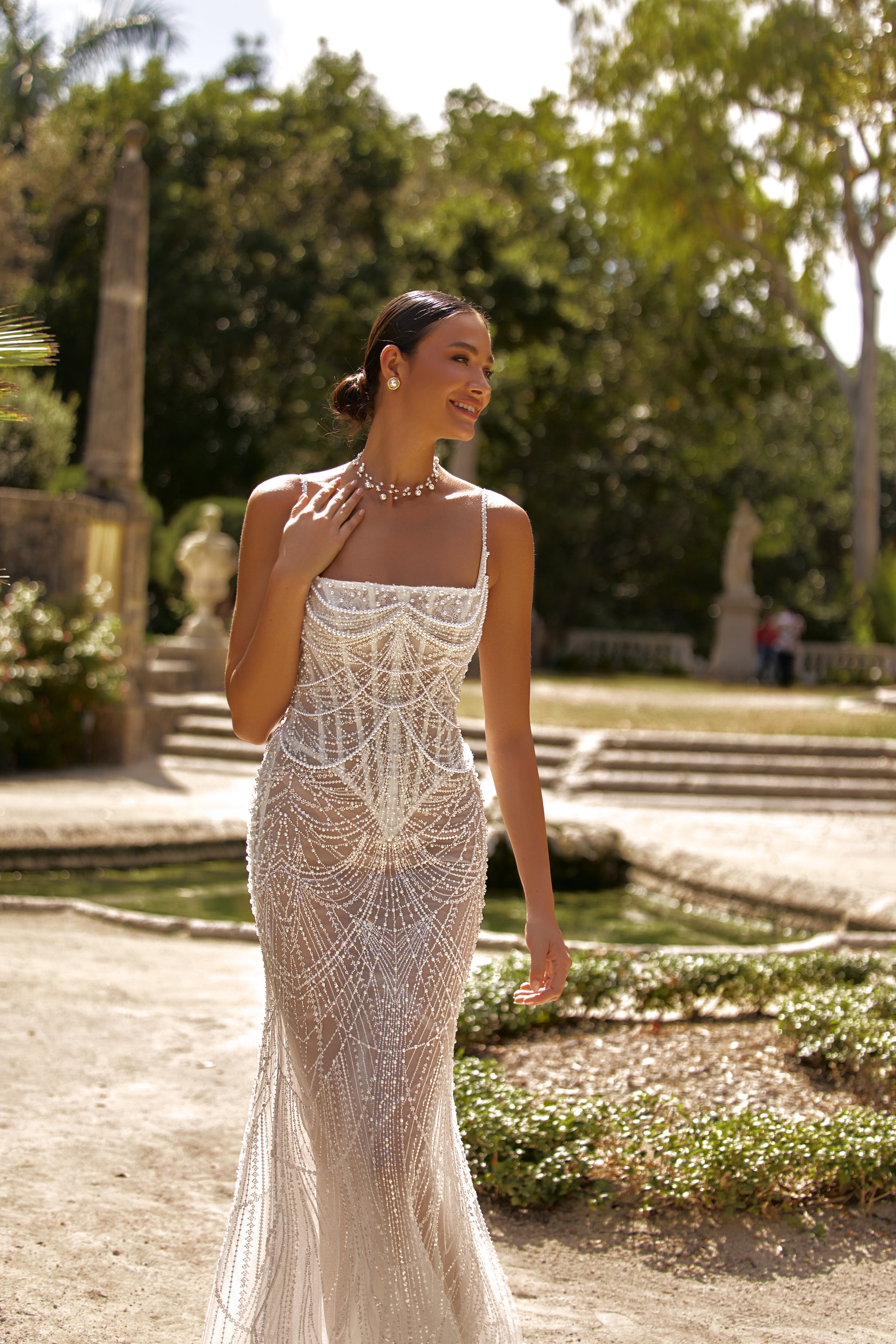 Luxurious wedding dress with lining featuring intricate beading, complemented by a stunning garden backdrop.