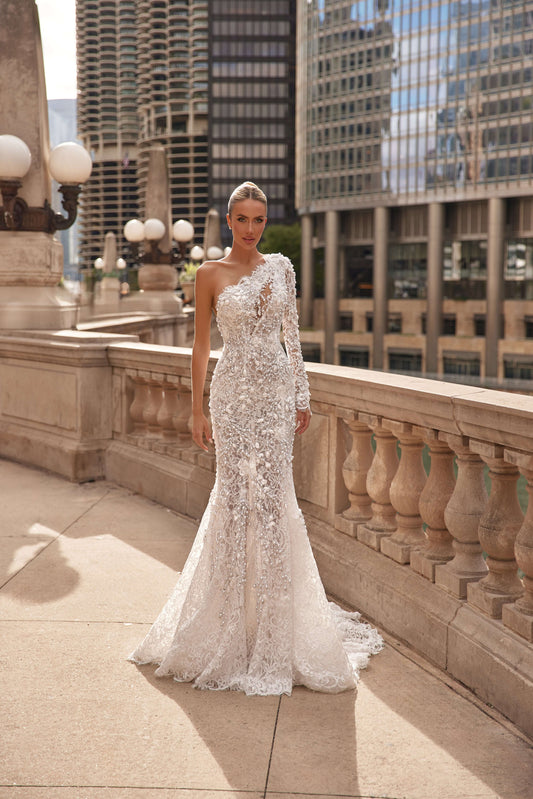 Model wearing an asymmetrical neckline mermaid dress in a stunning urban setting.
