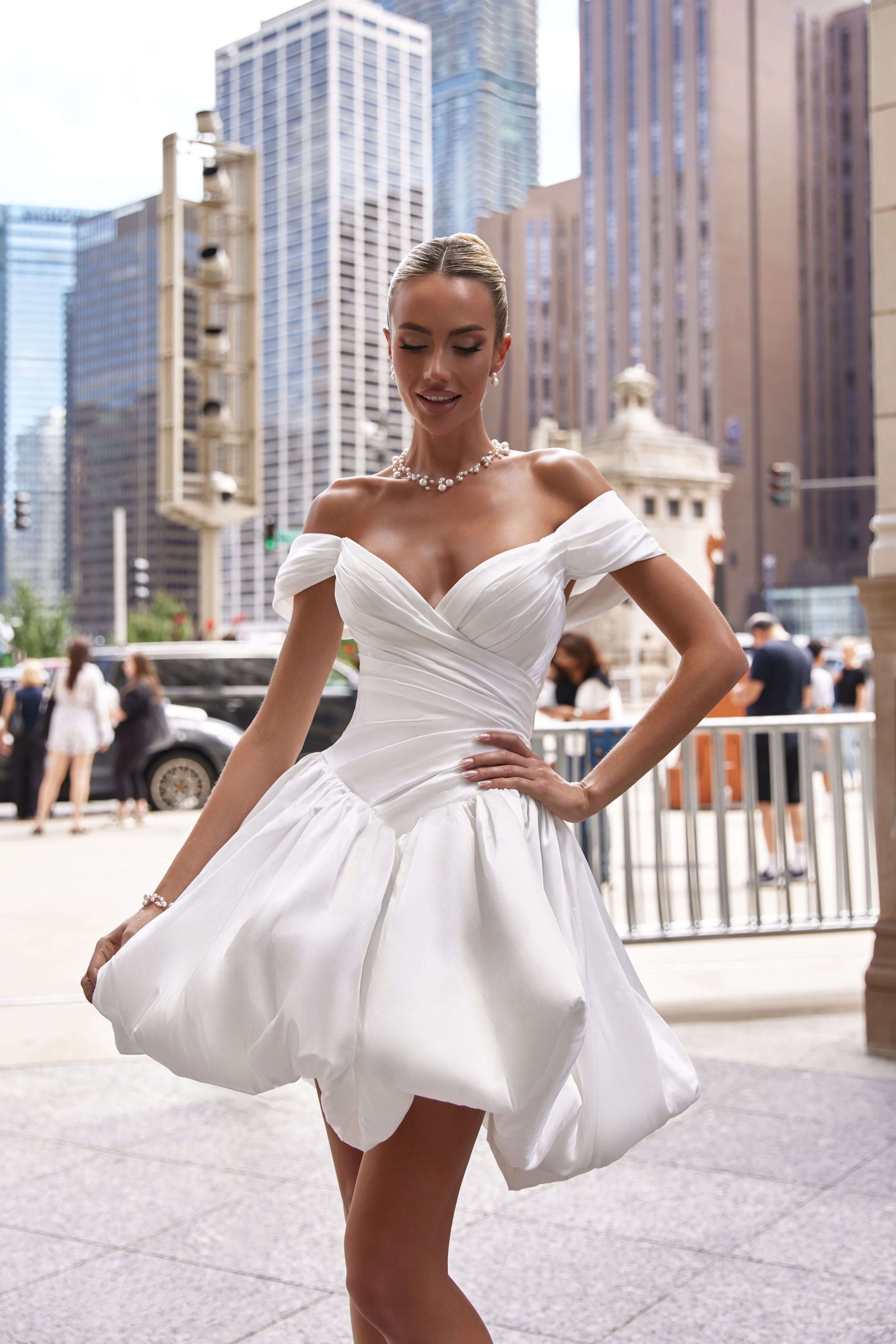 Model showcasing a stylish mini corset dress in white, perfect for making a fashion statement in the city.